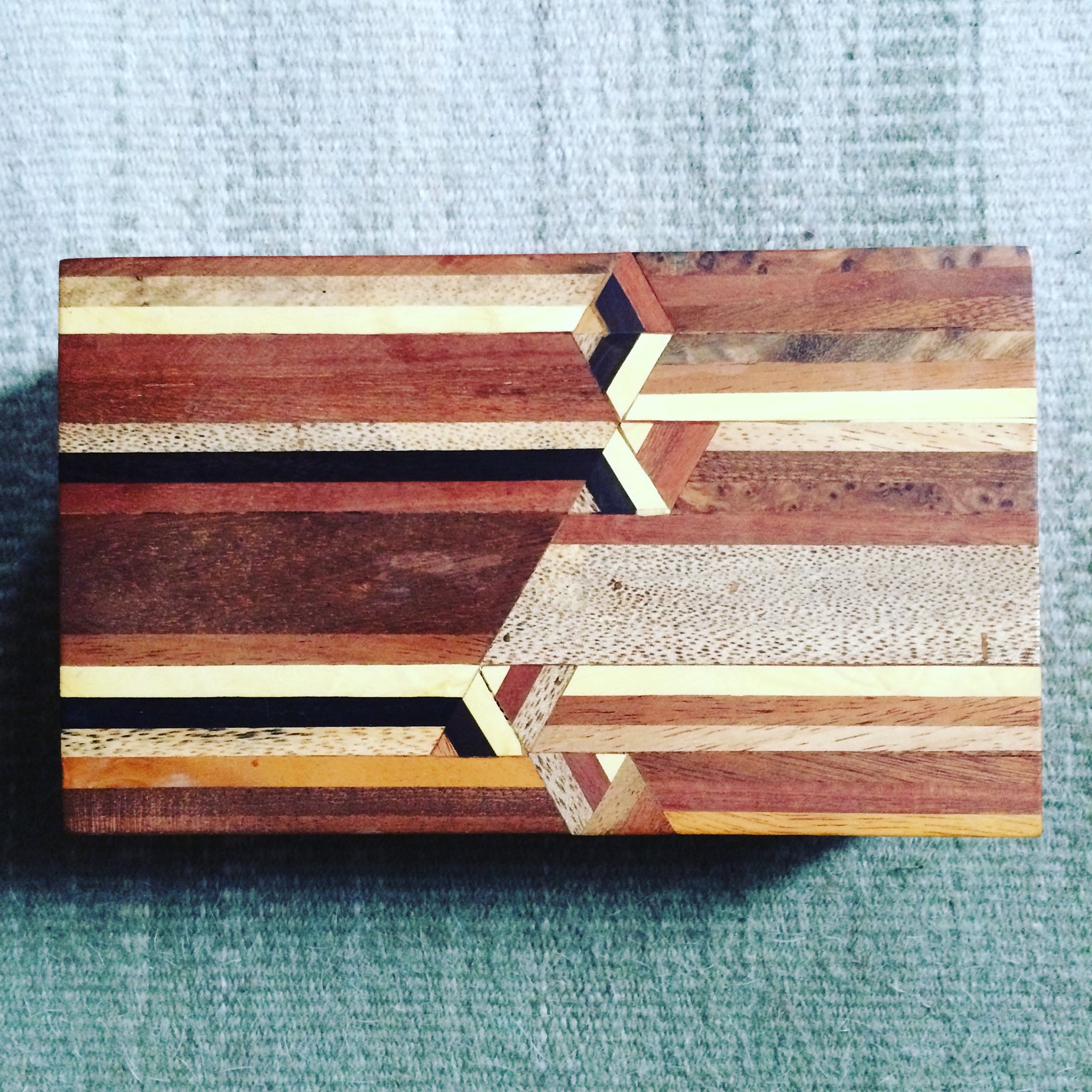 Boîte en marqueterie de bois fabriquée au Maroc, design original avec des motifs géométriques. Peut servir de boîte à bijoux ou boîte à cigares. Vue du dessus. Wooden marquetry box made in Morocco, original modern design, can be used as jewellery or cigar box.