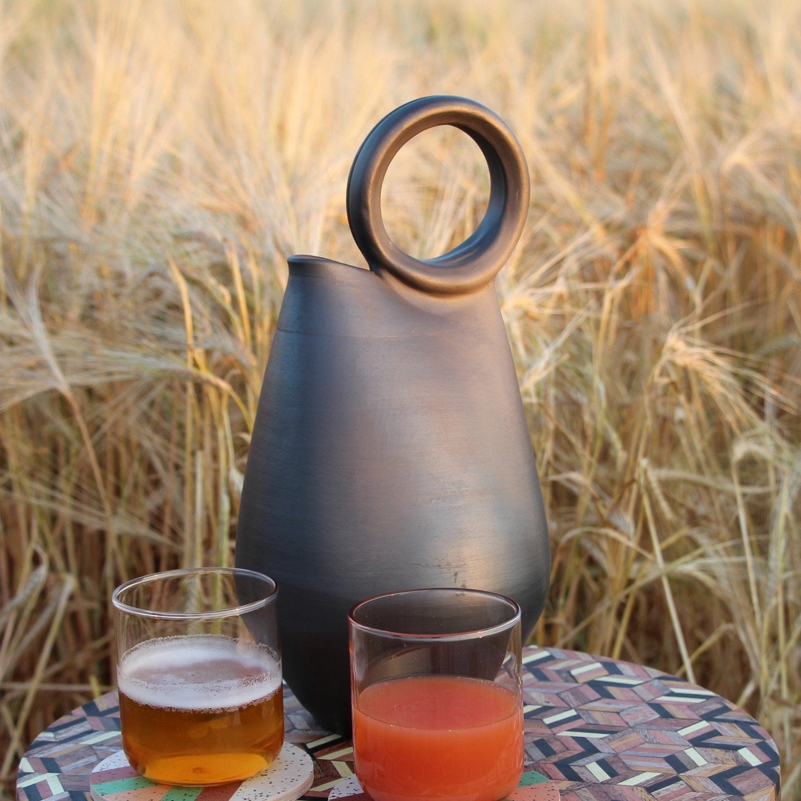 Carafe en céramique noire pour un instant apéritif au coucher de soleil, poterie artisanale - Ceramica negra decanter for an aperitif moment at sunset, handcrafted pottery.