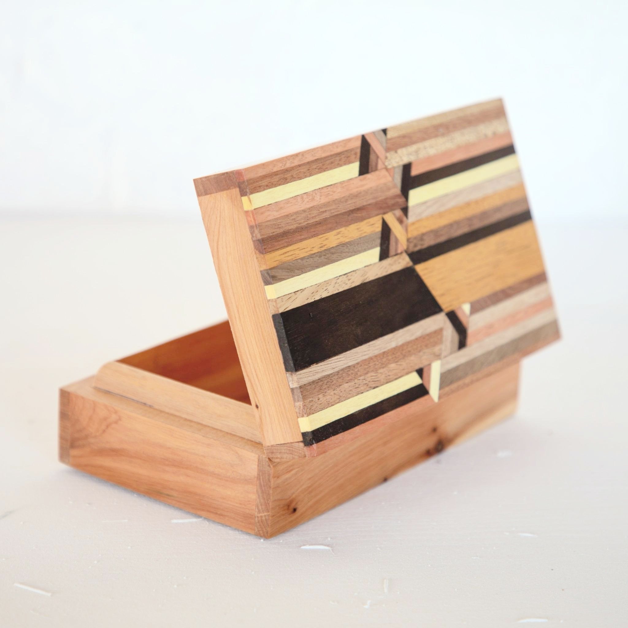 Boîte en marqueterie de bois fabriquée au Maroc, design original avec des motifs géométriques. Peut servir de boîte à bijoux ou boîte à cigares. Vue du dessus. Wooden marquetry box made in Morocco, original modern design, can be used as jewellery or cigar box.