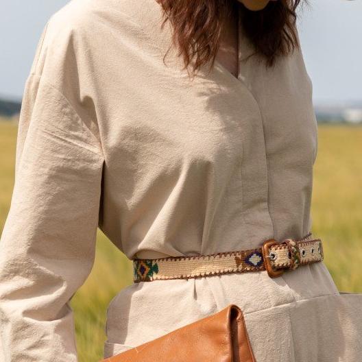Femme portant une ceinture du Guatemala en cuir avec dessin azteque beige sur une combinaison beige - Woman wearing a beige aztec pattern Guatemala leather belt worn over a beige jumpsuit