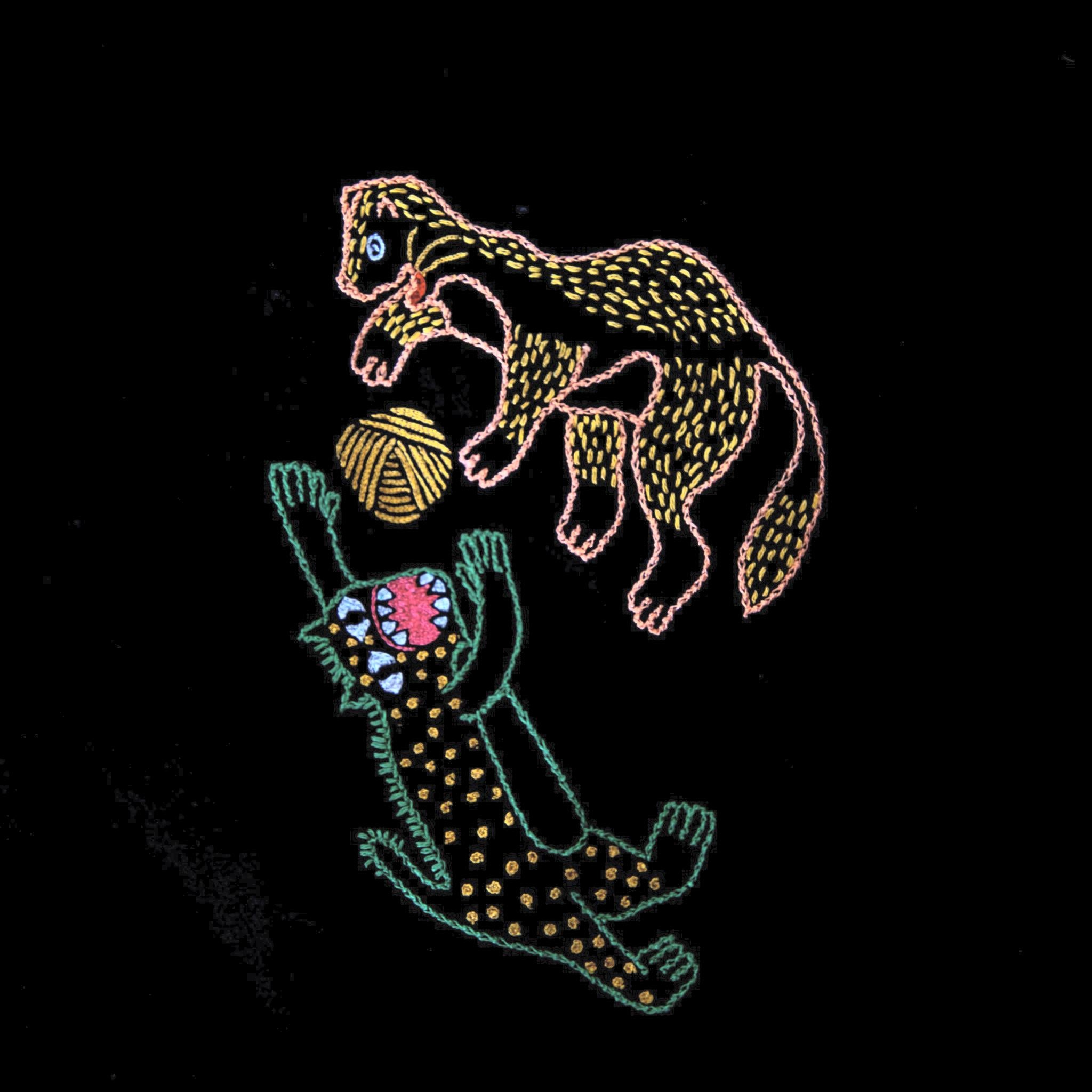 Femme dans un champ de blé portant une étole en pashmina noire brodée réalisée en collaboration avec Laïte Works. Woman in a wheat field wearing a black embroidered pashmina stole, in collaboration with Laïte Works.