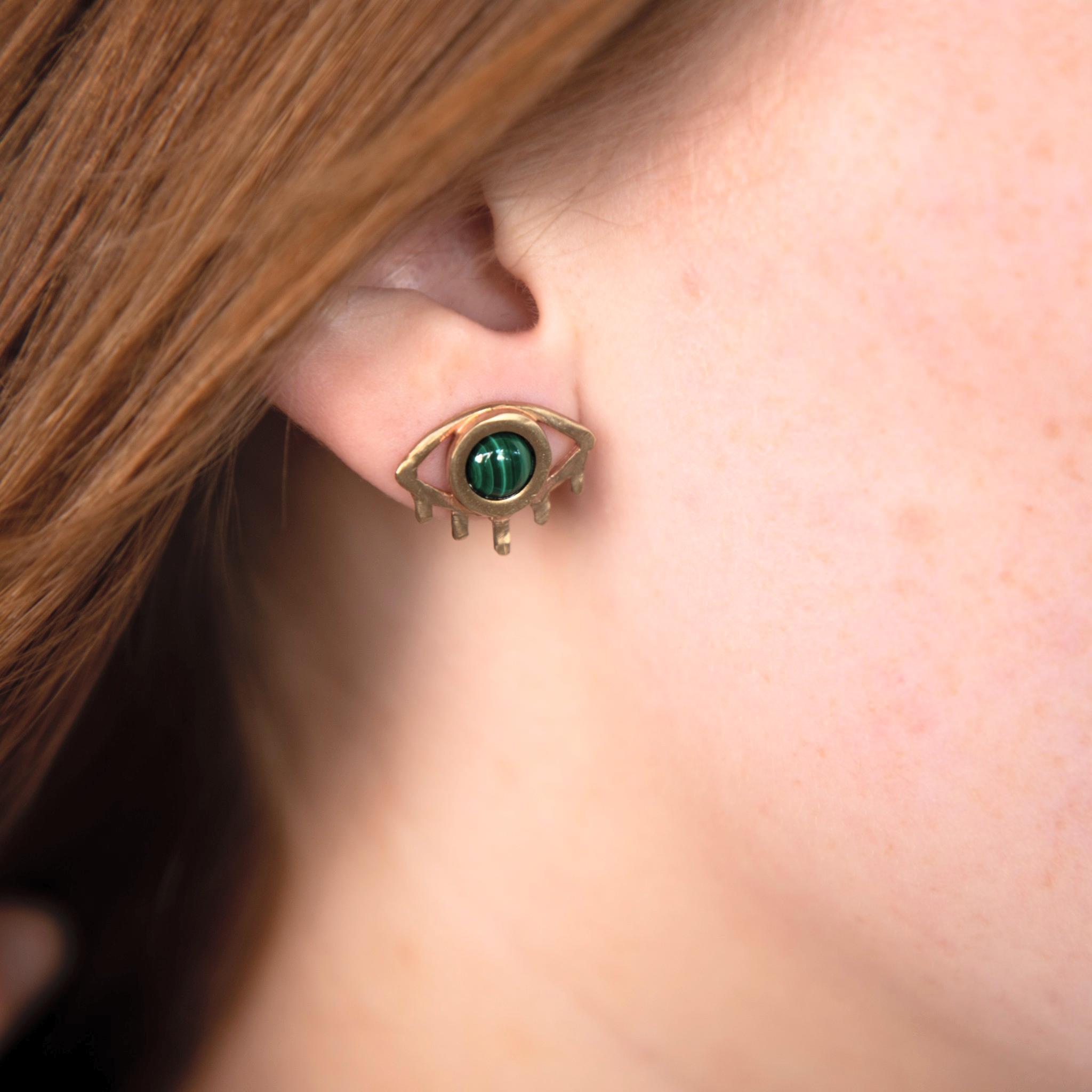 Femme aux cheveux roux ou blond vénitien portant des boucles d'oreilles oeil et pierre de malachite, fabriquées à Chicago par la créatrice THERESE KUEMPEL. Woman with ginger hair wearing eye and malachite earrings, handcrafted in Chicago by THERESE KUEMPEL.