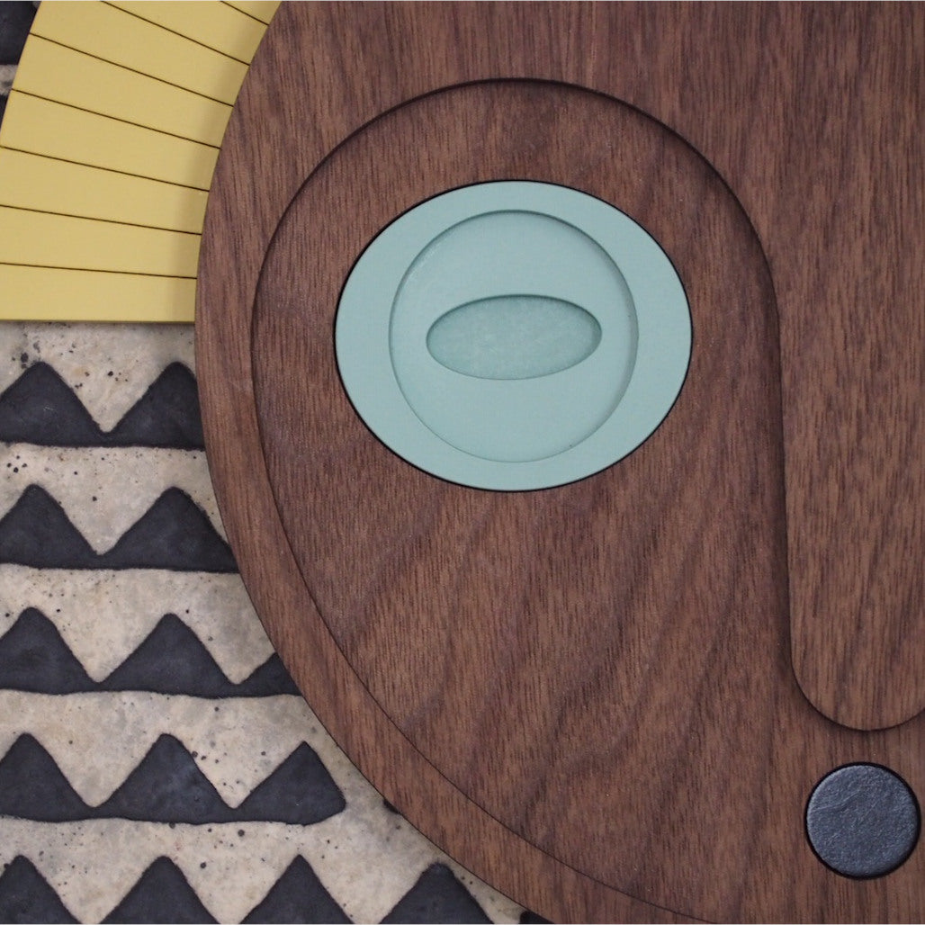 Décoration murale en bois, représentant un masque aux yeux jades et couronne jaune, en édition limitée par UMASQU. Wooden wall decoration, evoking an african mask with jade eyes and yellow crown made by UMASQU in limited edition.