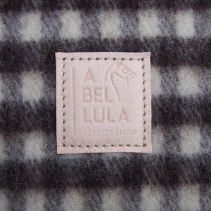 Femme portant un châle à carreaux vichy en laine espagnole et une ceinture de polo argentine. Woman wearing a Spanish wool vichy checked shawl and an argentinian polo belt.